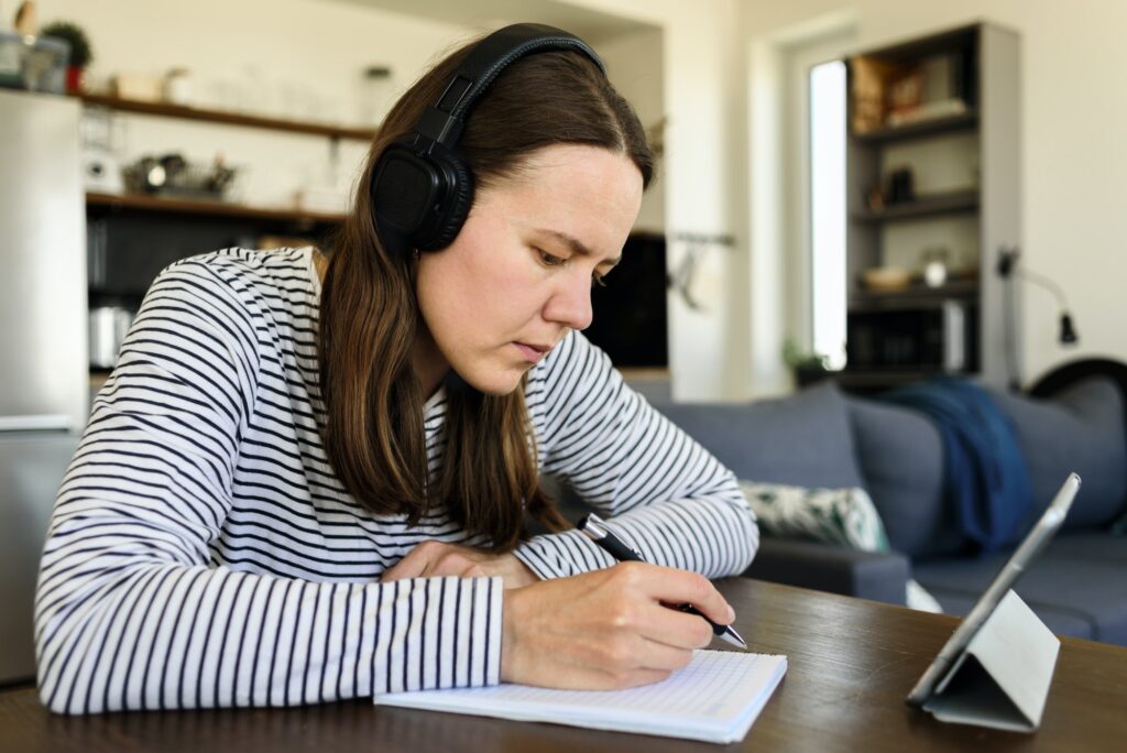 Woman in headphones learning at home